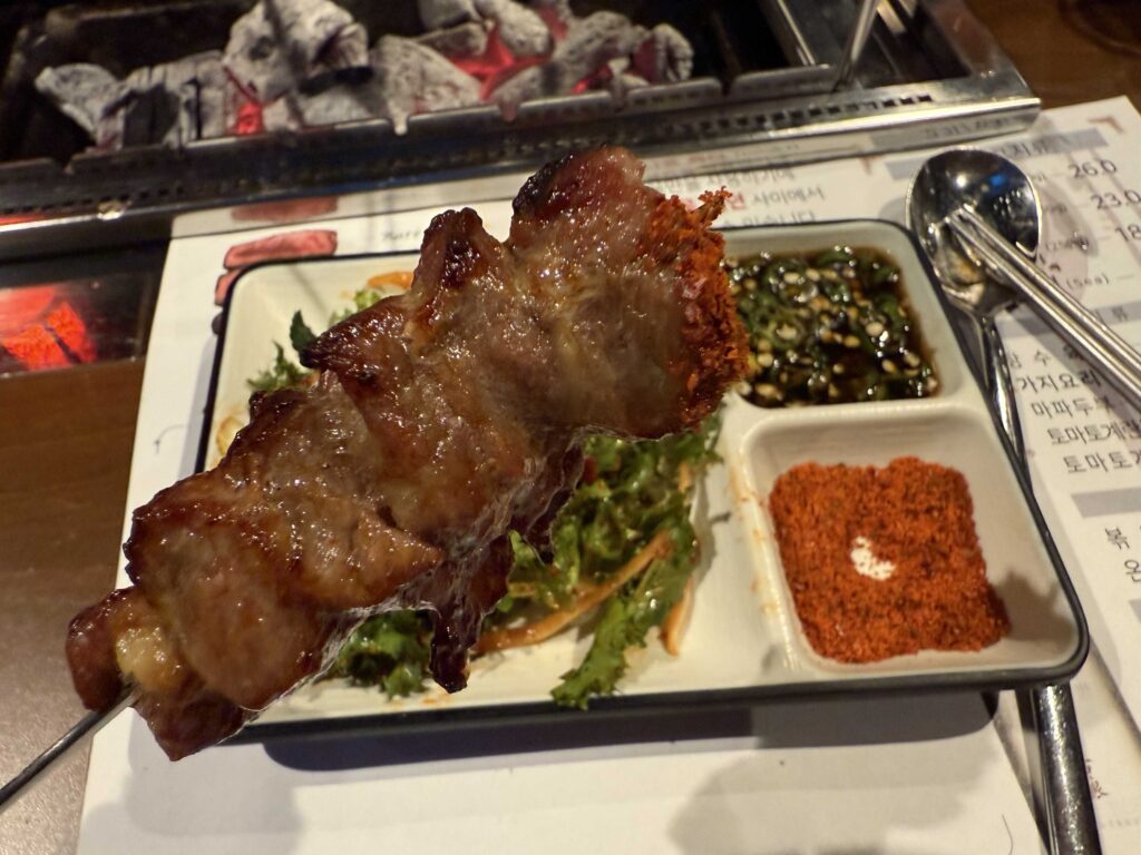 Iga Ne lamb rib served on plate with dipping sauces