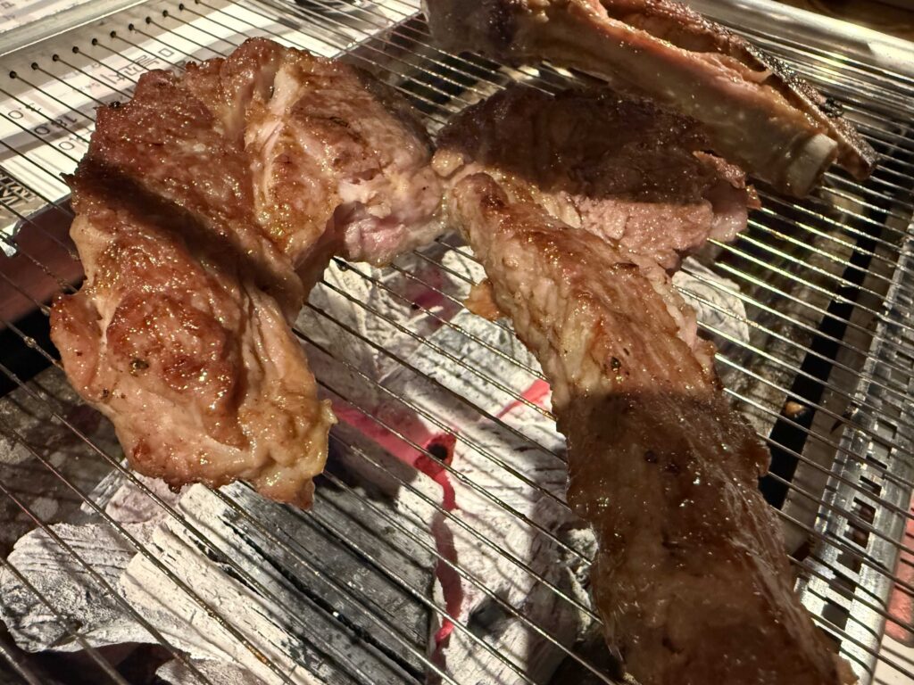 Lamb ribs grilling on charcoal grill at Iga Ne
