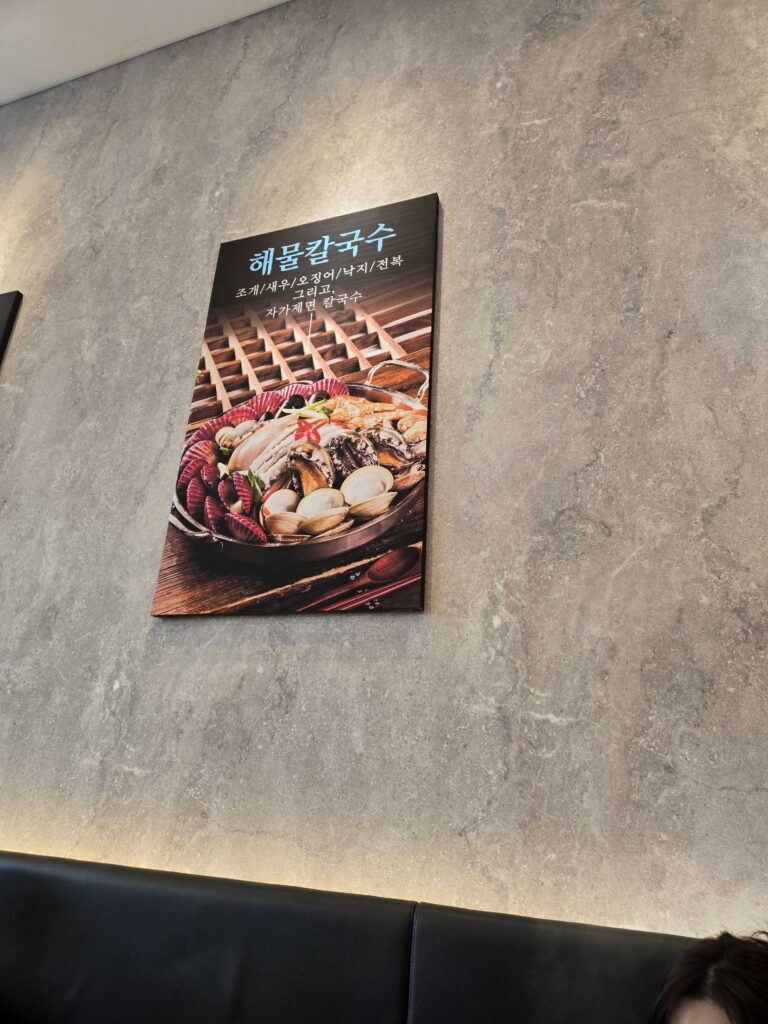 Park Seung-gwang wall menu showing haemul kalguksu ingredients - clams, shrimp, squid, octopus, abalone