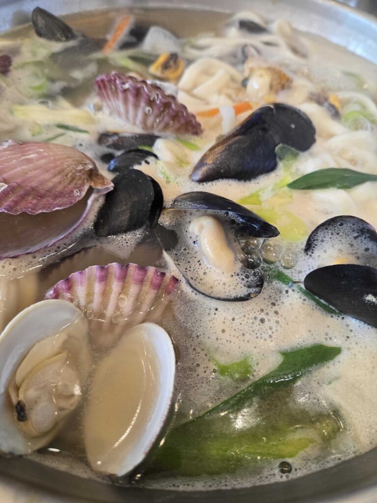 Haemul kalguksu pot mid-cook with milky white broth at Park Seung-gwang