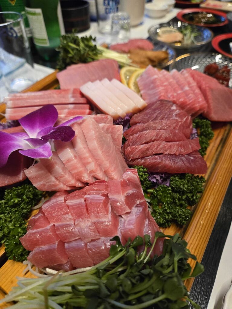 tuna sashimi platter otoro chutoro akami wooden board purple orchid garnish