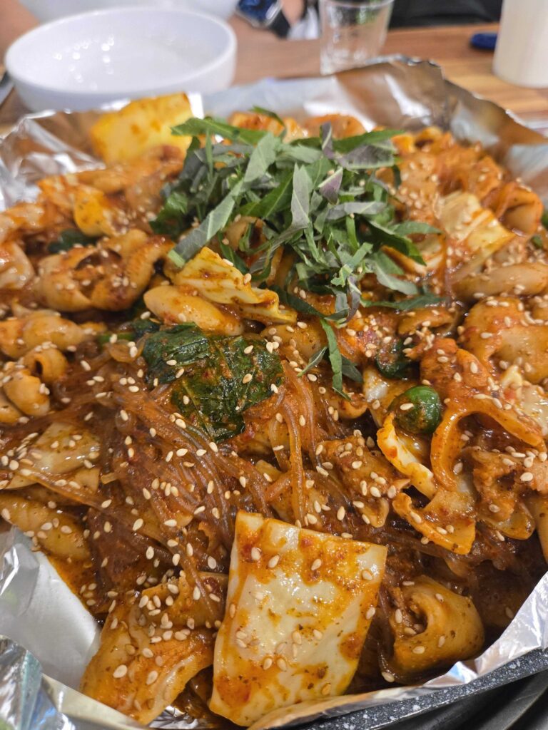 Spicy vegetable gopchang at Taeyang Gopchang Gundae with sesame seeds and green onion toppings