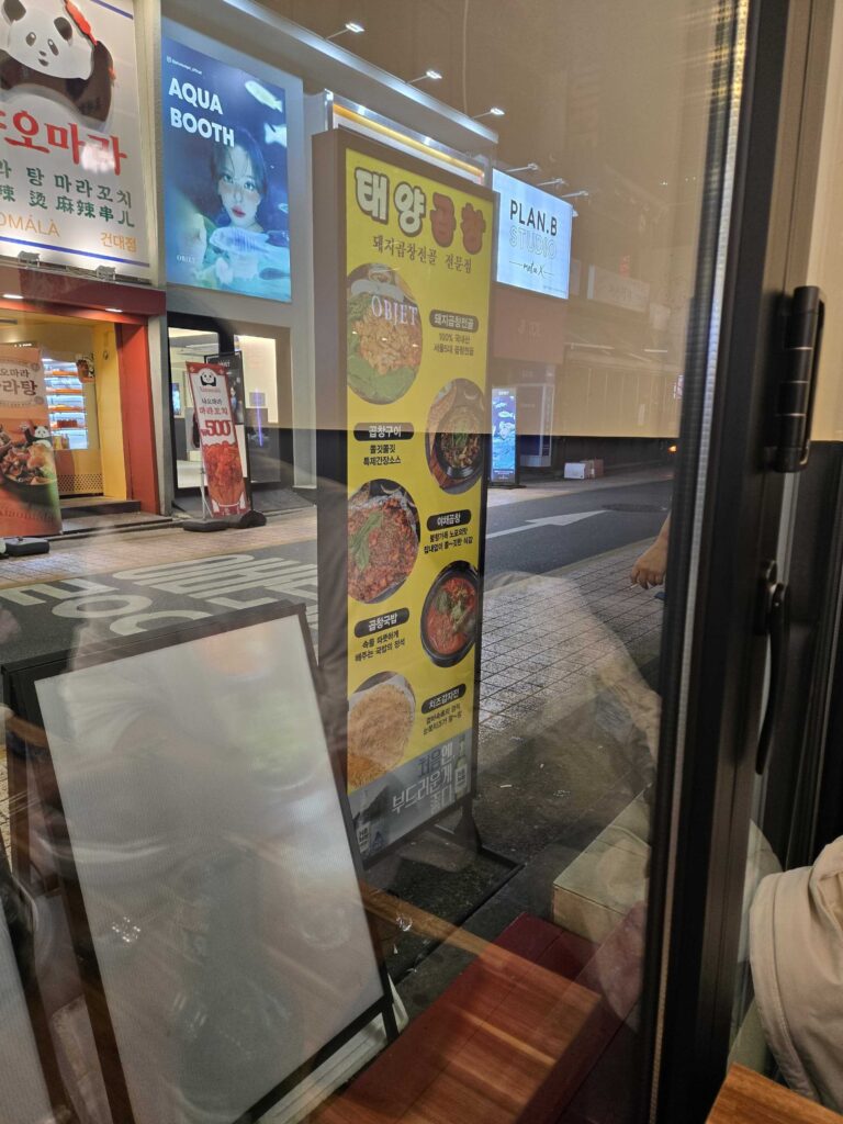 Restaurant entrance door with yellow menu banner showing signature Korean intestine dishes