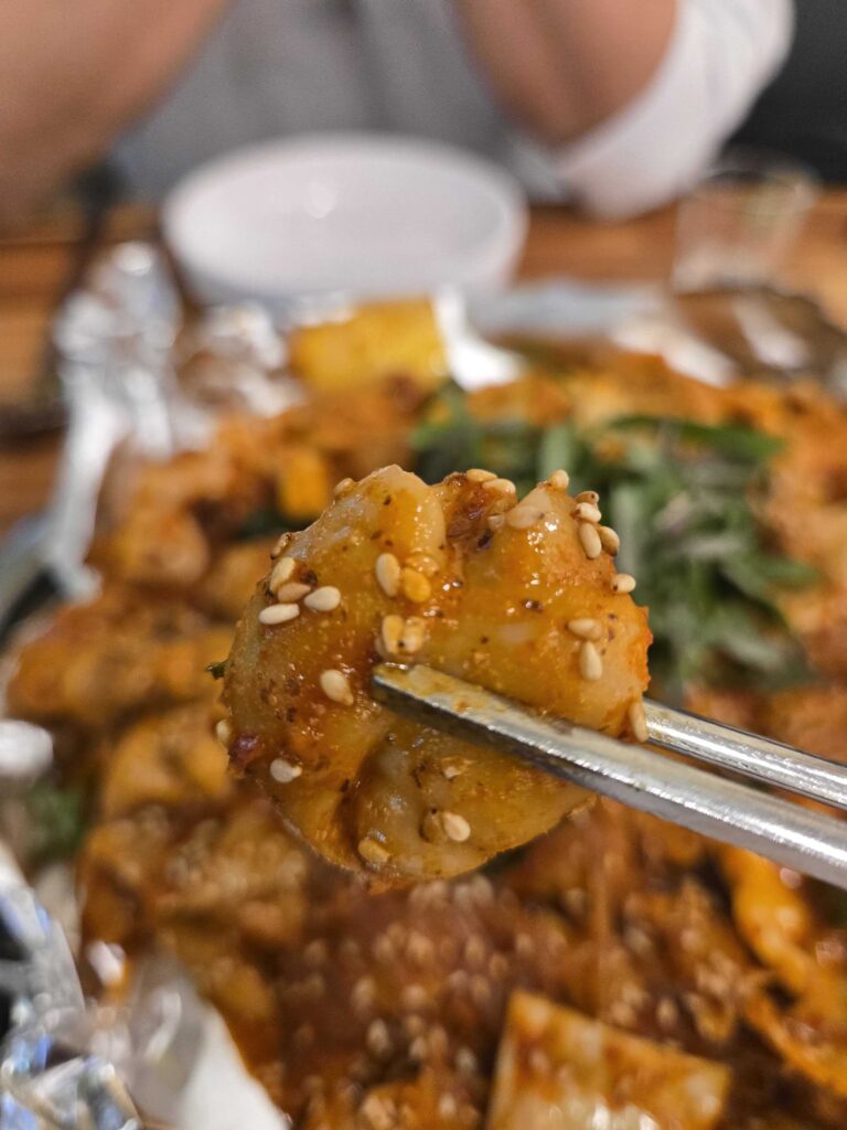 Chopsticks holding chewy gopchang at Taeyang Gopchang Gundae Seoul restaurant