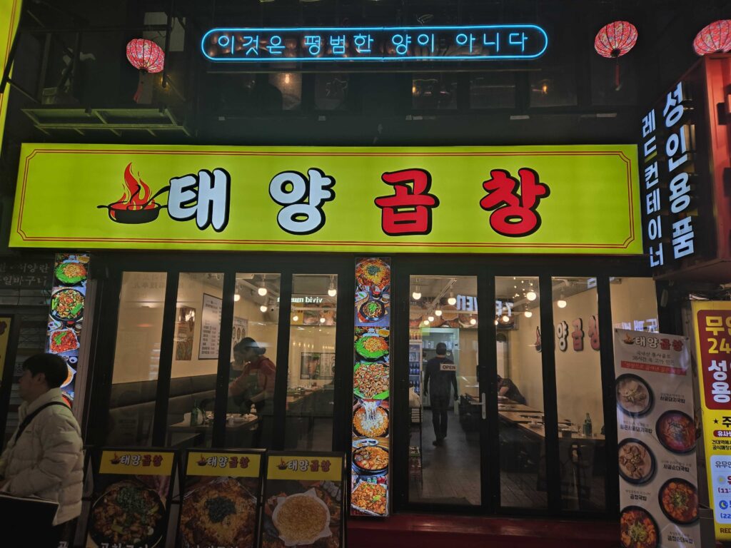 Bright neon storefront sign at night near Konkuk University Station in Seoul