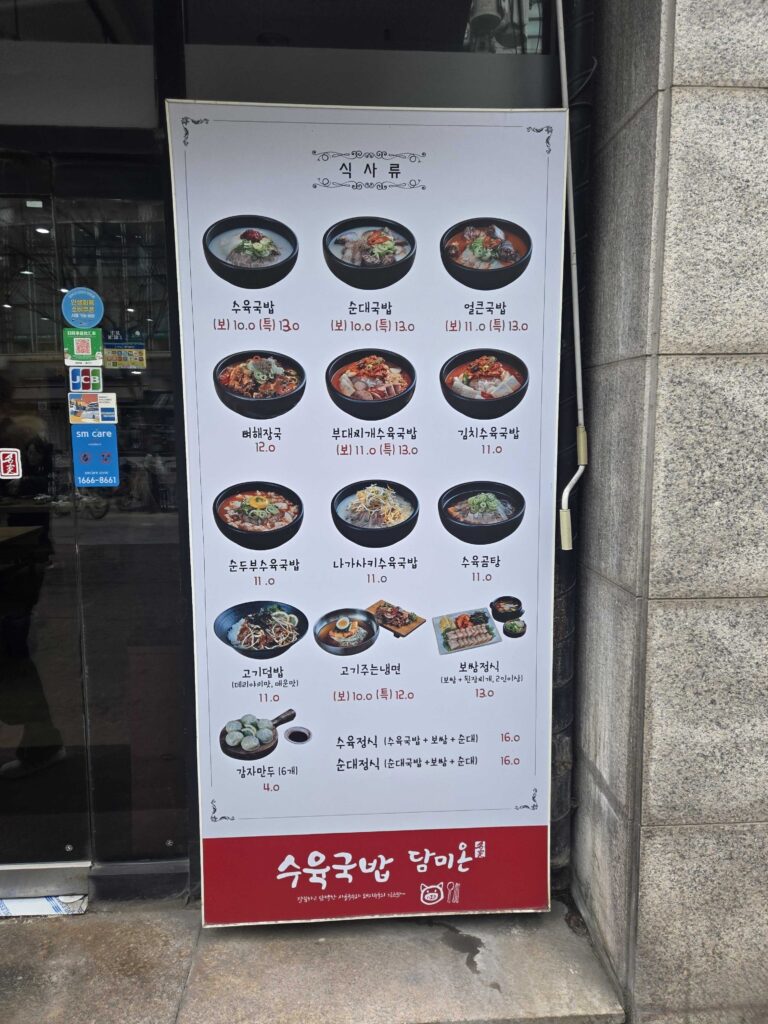 Close-up of budae suyuk gukbap at Dammion Seongsu showing bubbling red broth with ramyeon noodles and sausage