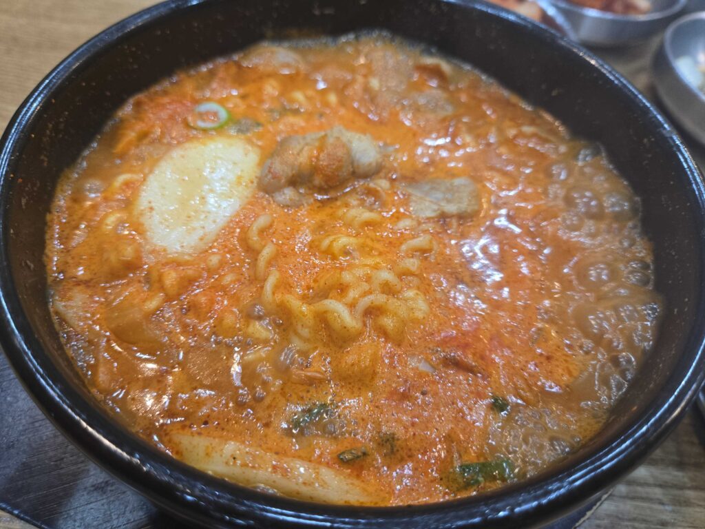Close-up of bubbling budae suyuk gukbap at Dammion Seongsu in a stone pot