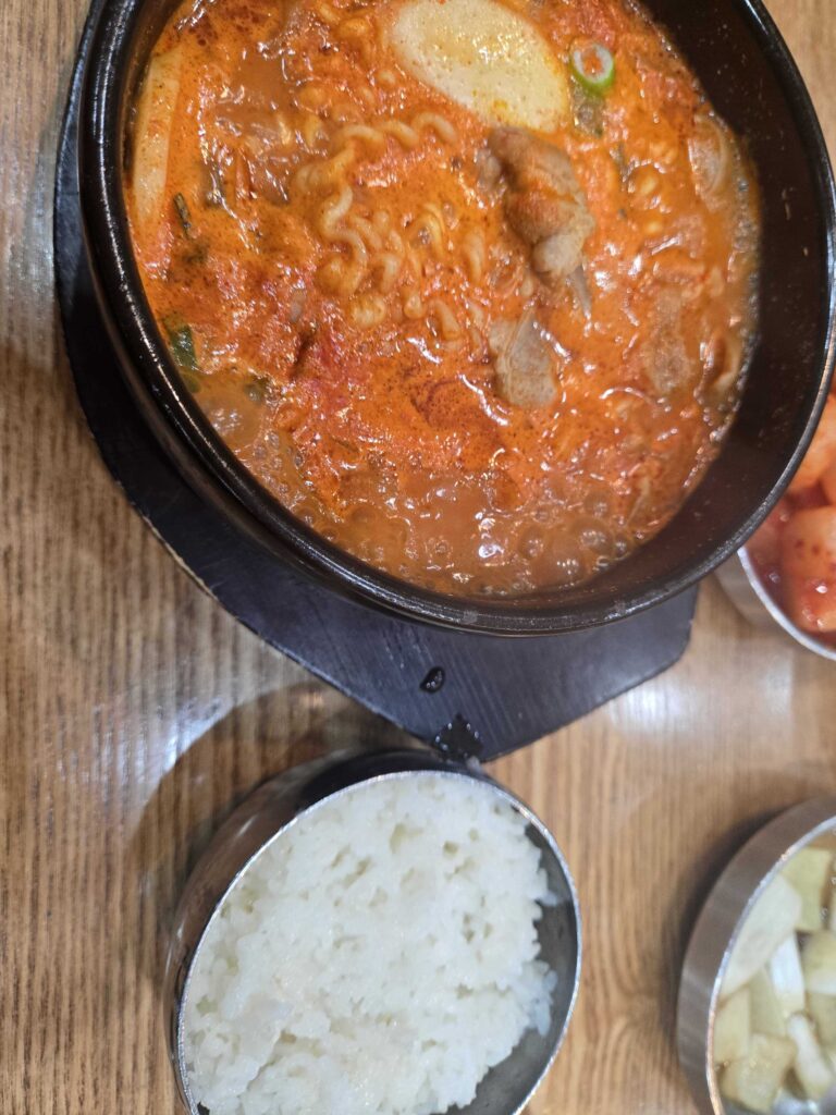 Overhead shot of the full meal at Dammion Seongsu — gukbap, rice, and banchan side dishes
