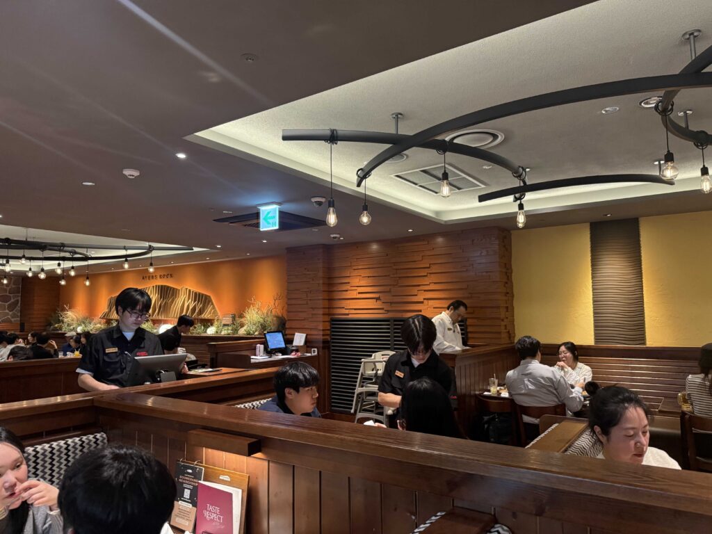 Warm interior lighting at Outback Steakhouse Jamsil with Lotte World in background