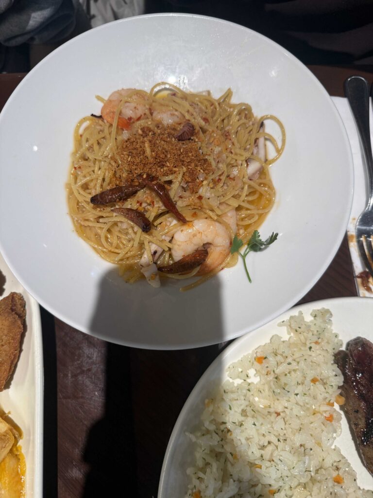 Spicy seafood aglio olio pasta with shrimp and mussels on a white plate