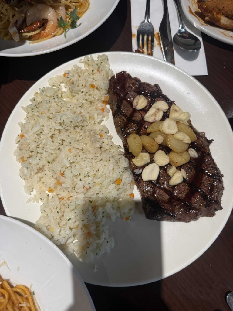 Garlic rib-eye steak served with steamed rice on a sizzling plate