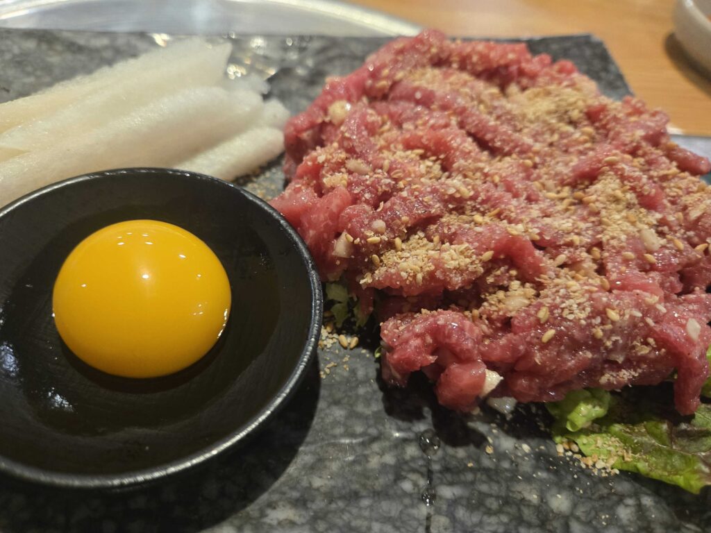 Perfectly grilled golden-brown pork belly slices with crispy caramelized fat edges on the stone grill