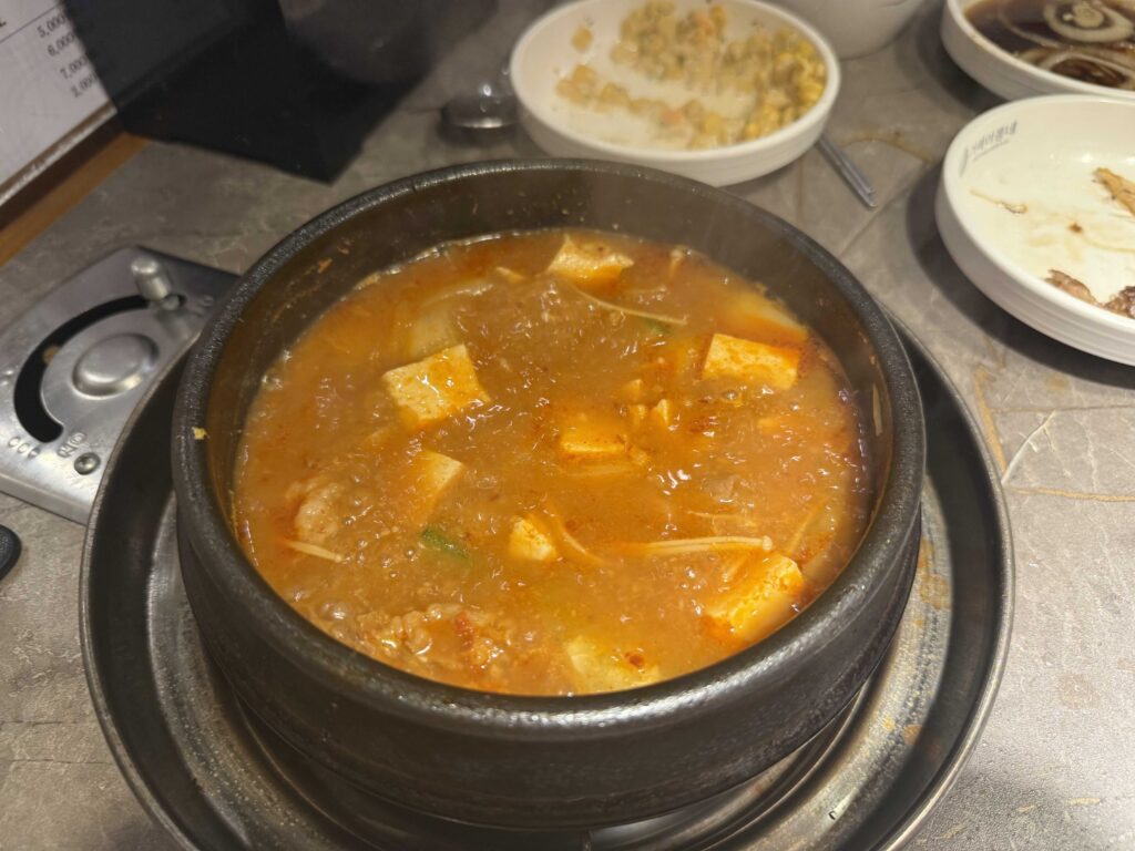 Bubbling kimchi jjigae in stone pot at Geobugi Dongnae