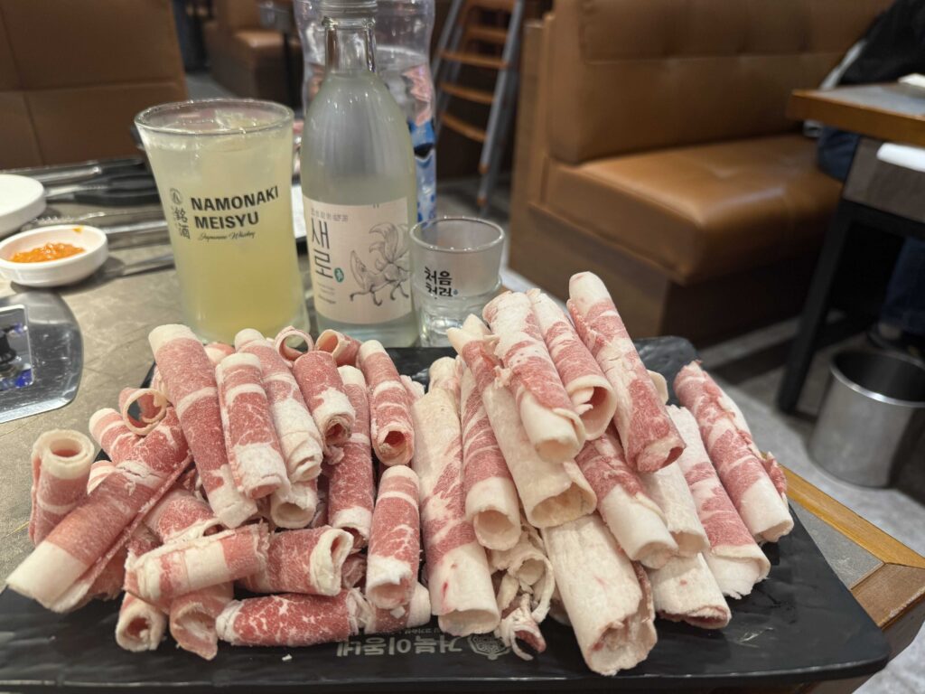 Three cuts of fresh pork on black slate plate at Geobugi Dongnae Hanam