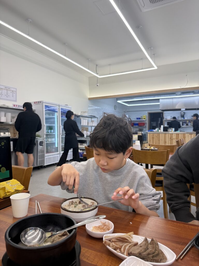 Sundae Korean blood sausage held with chopsticks close-up Dalbit-e Goeun Sokcho
