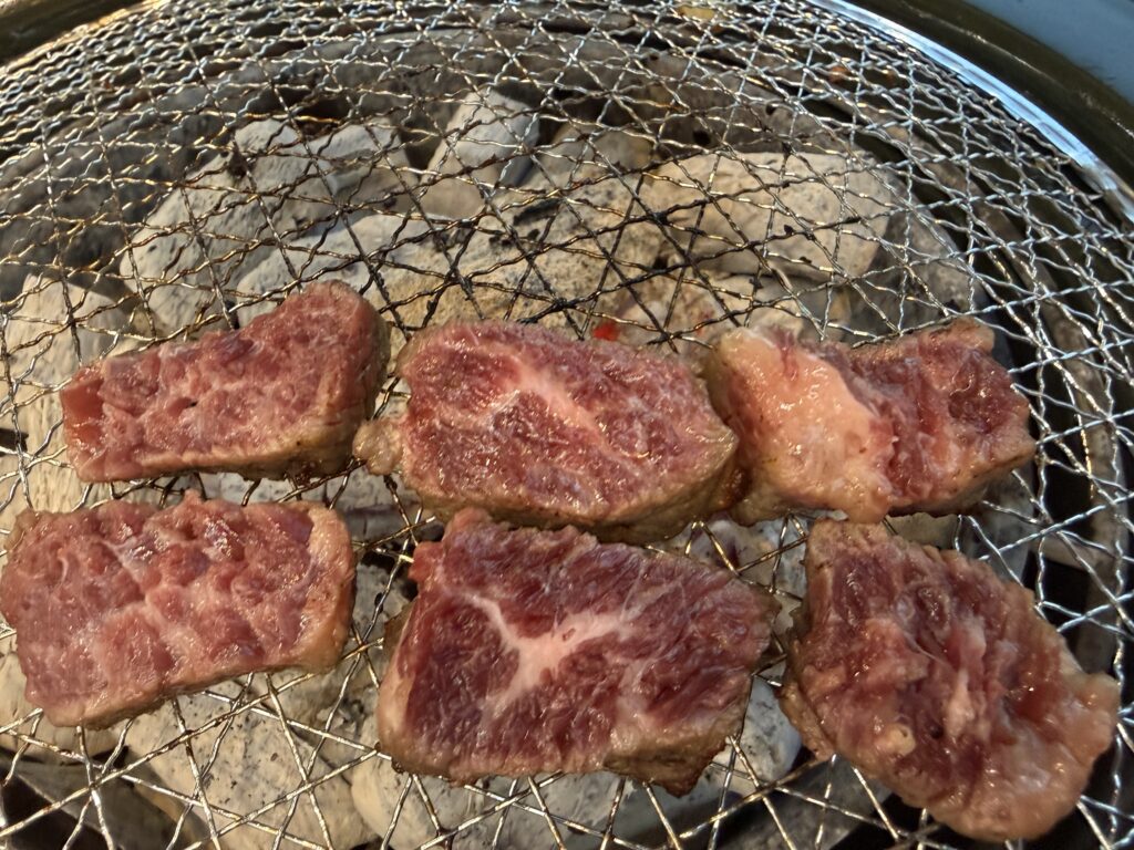 Premium beef slices perfectly arranged on charcoal grill