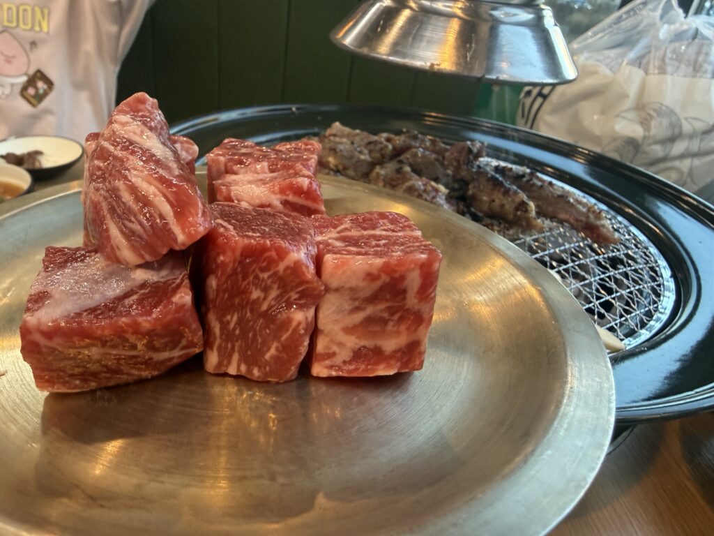 Thick marbled beef chunks ready for charcoal grill at Korean BBQ