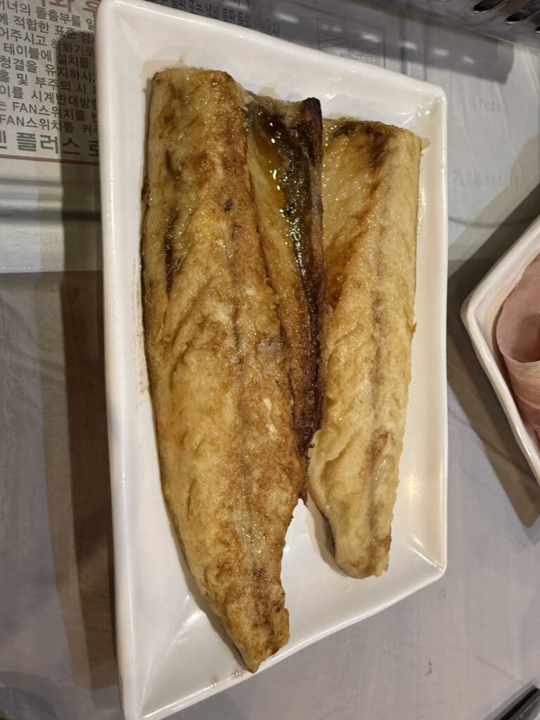 Korean side dishes banchan at Mannajeong Wonju with grilled fish and kimchi