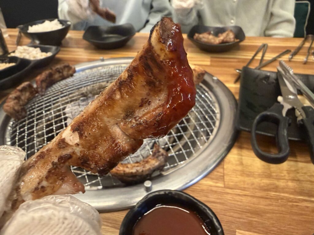 Spicy maeun pork ribs cooking on a tabletop charcoal grill