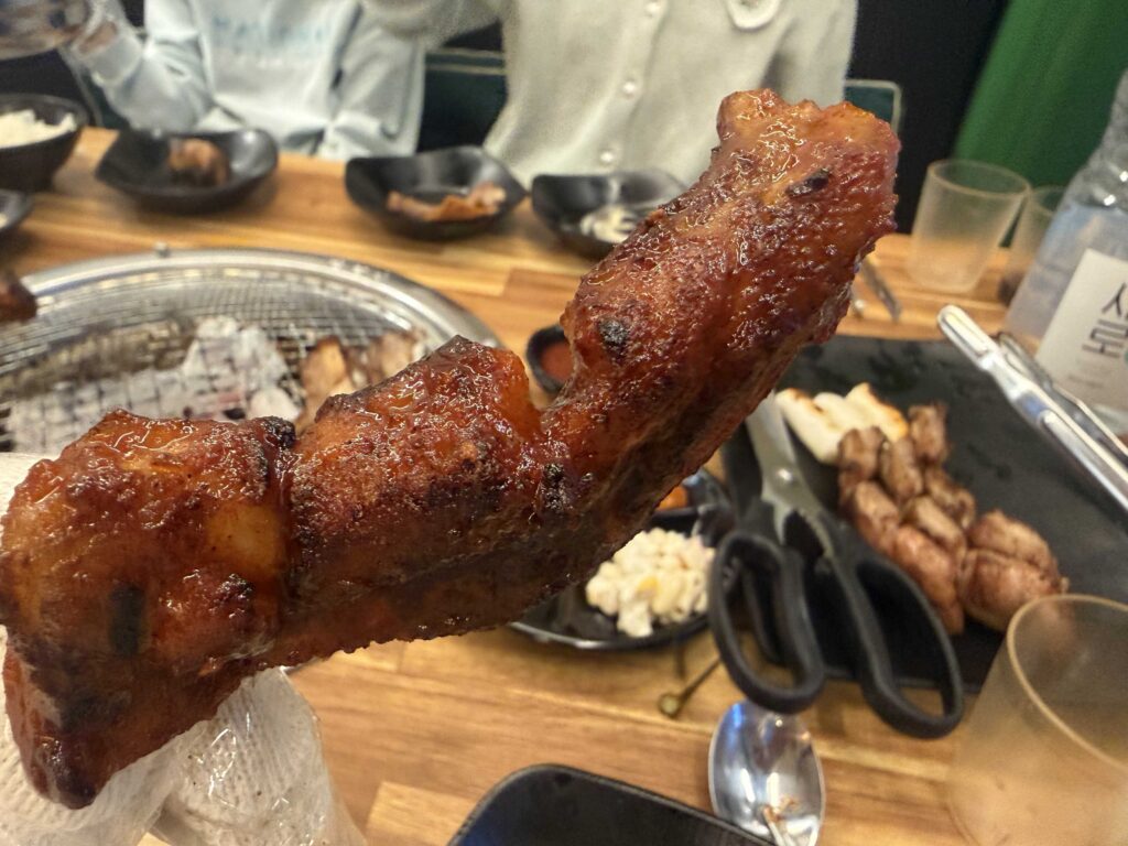 Korean BBQ pork ribs and onion slices grilling together on charcoal