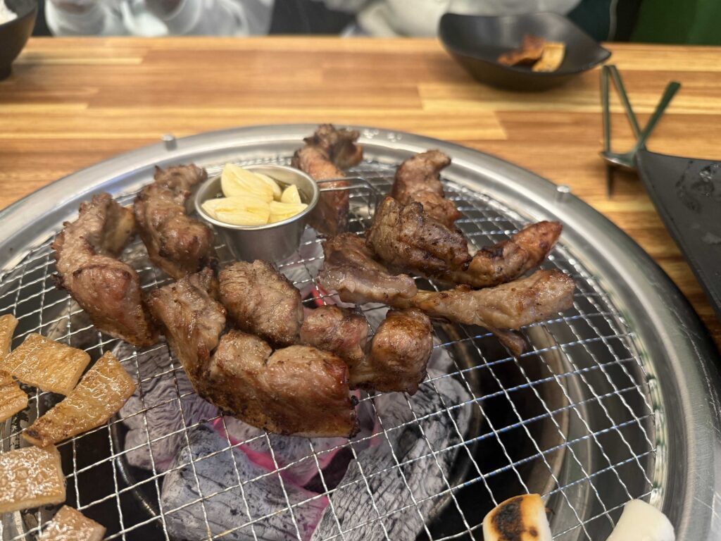 Free pork skin and rice cakes grilling on a charcoal barbecue