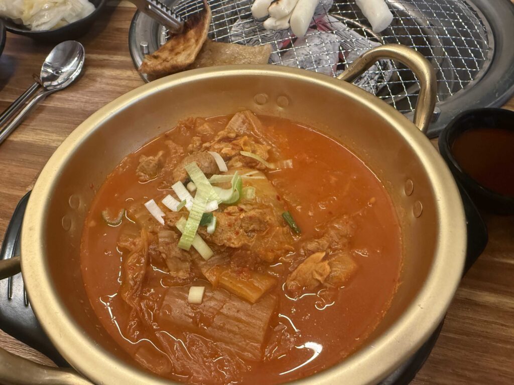 Bubbling Korean jjigae stew served alongside grilled pork ribs