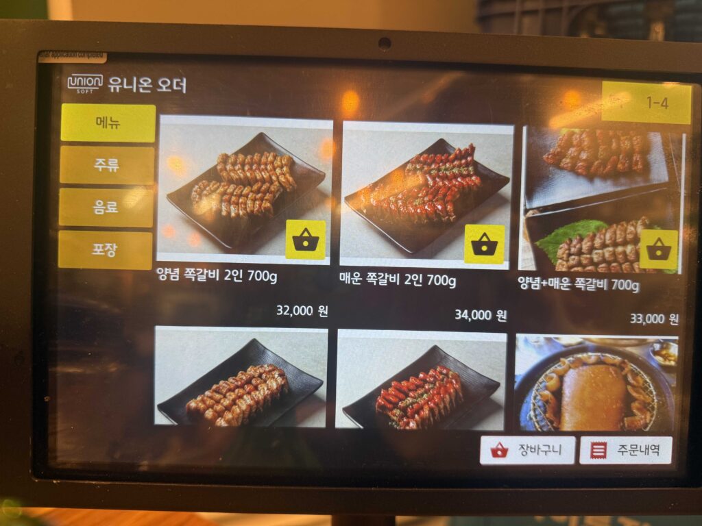 Grilled pork ribs and charred rice cakes on a sizzling barbecue plate