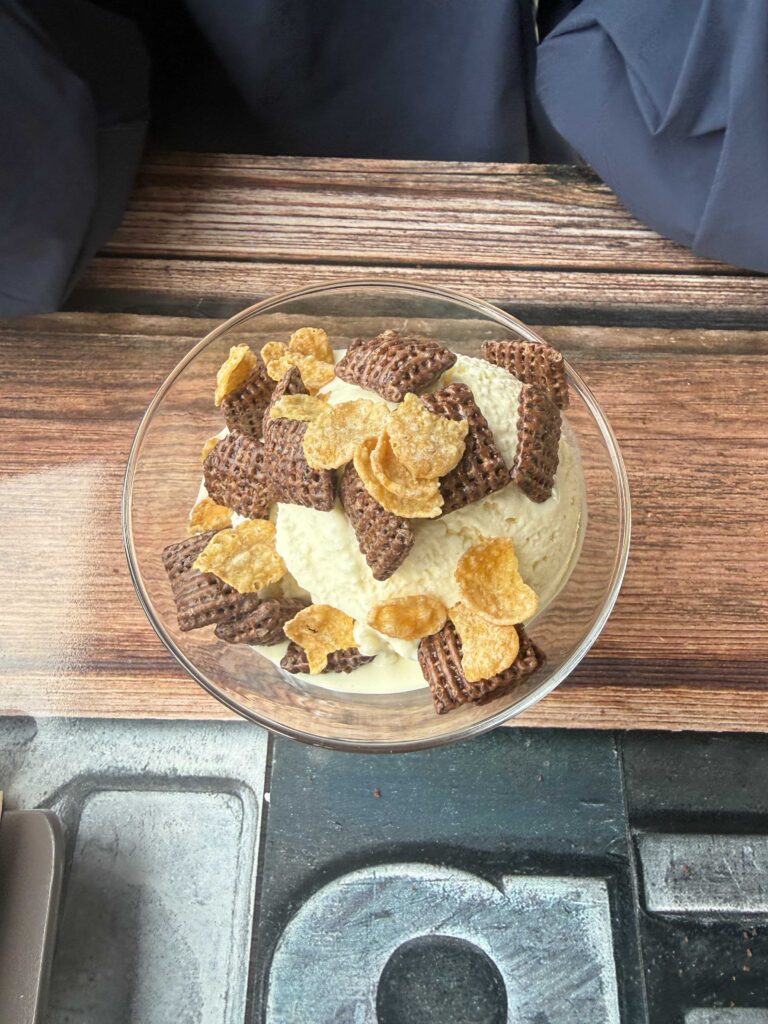 Top-down view of ice cream sundae with cereal and chocolate toppings
