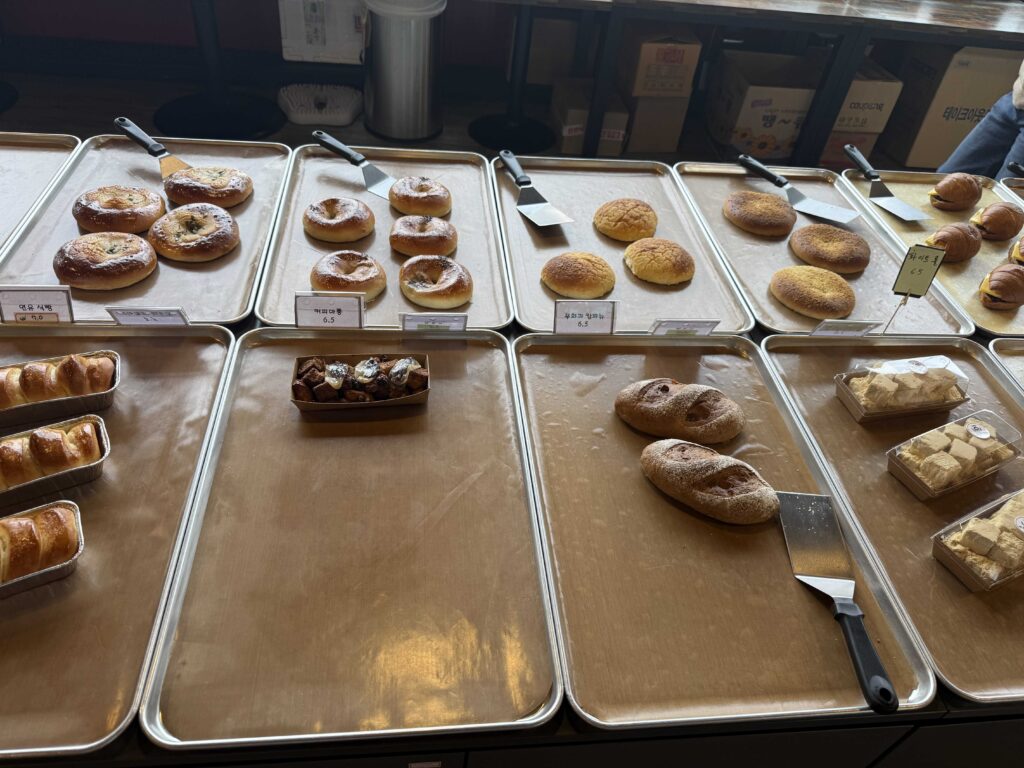 Bakery display trays with various Korean breads and buns at Baegundang Bakery Pocheon
