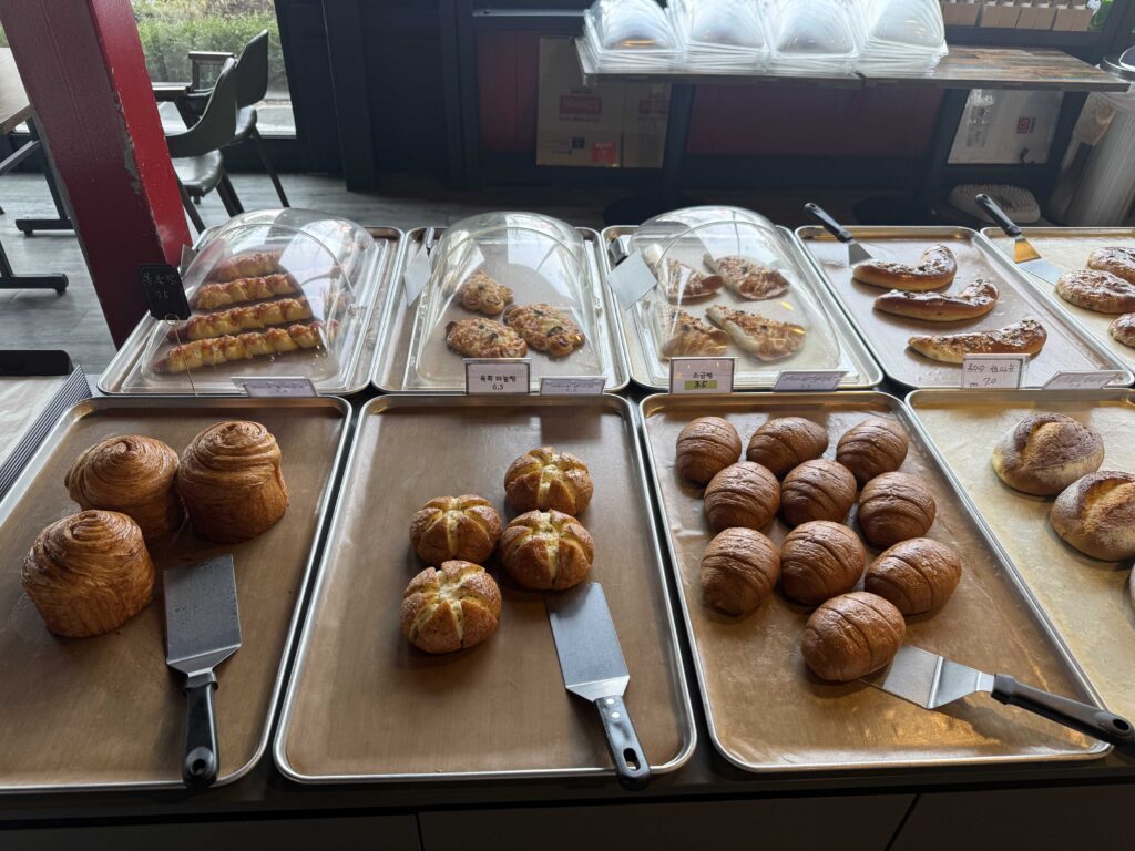 Child reaching for freshly baked bread at Baegundang Bakery Pocheon