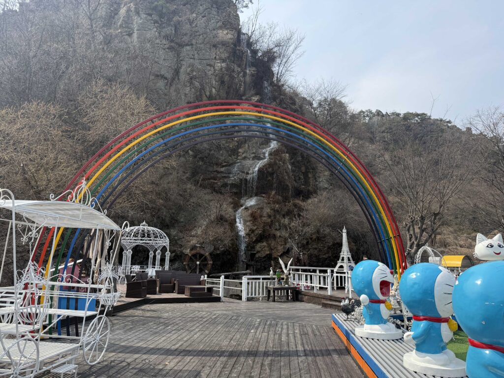 Rainbow arch with Doraemon character statues outside Baegundang Bakery Pocheon