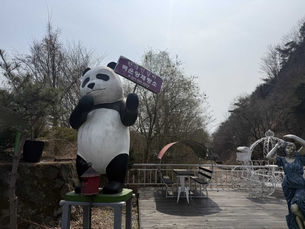 Giant panda statue holding Baegundang Bakery sign outside the cafe