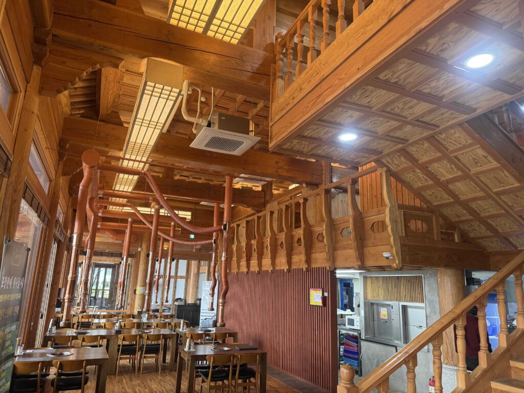 Traditional wooden interior with copper chimneys over BBQ tables
