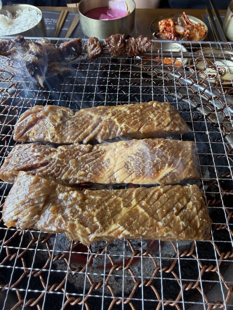 Galbi on charcoal grill with rice and banchan