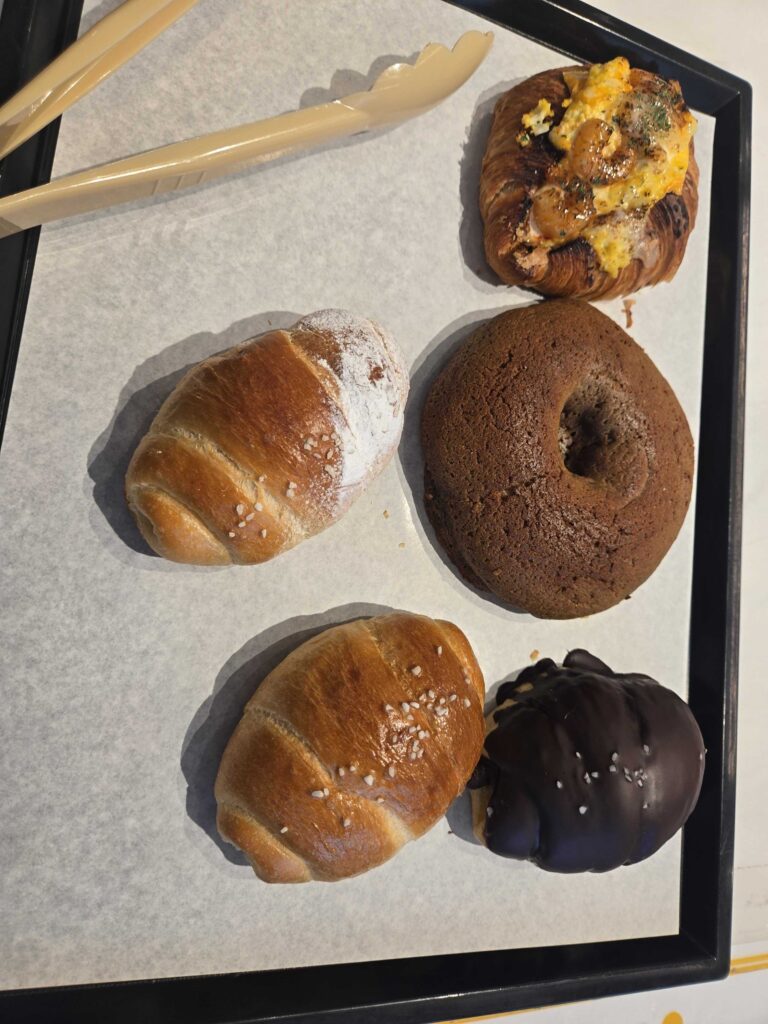 Okuku Bakery bread tray with selected items including salt bread egg shrimp croissant chocolate items