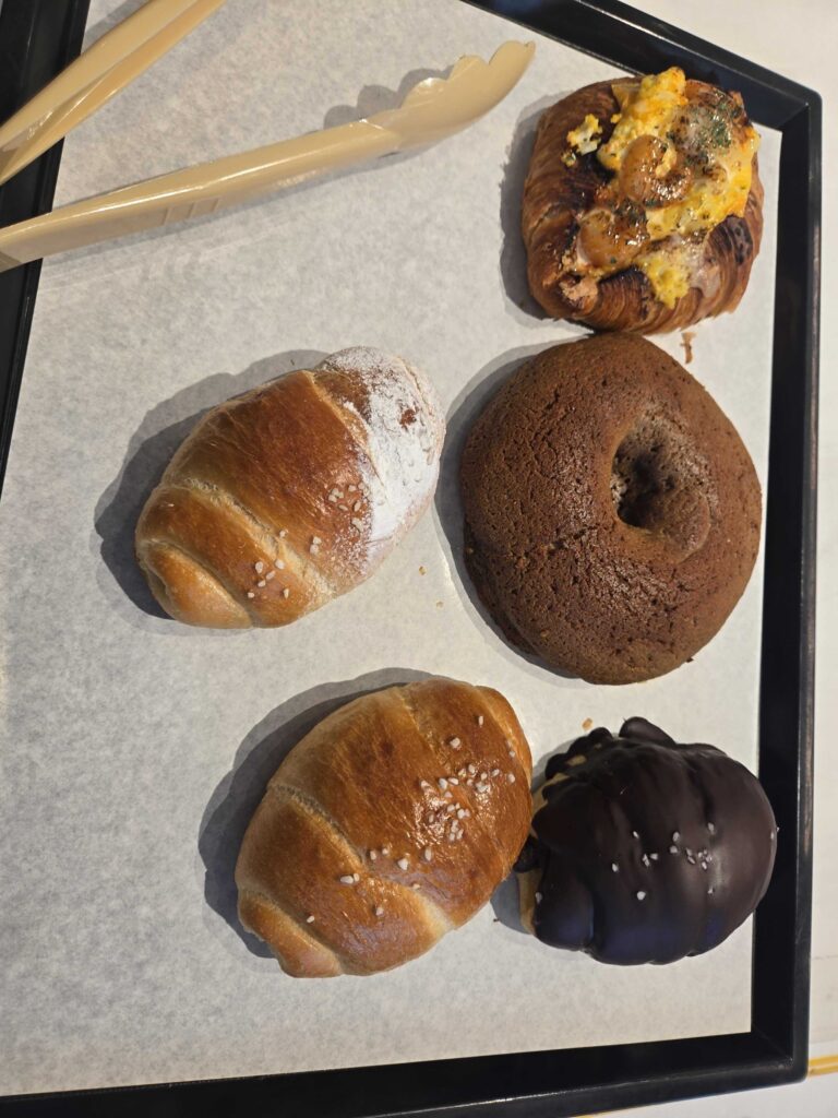 Okuku Bakery bread selection closeup with salt bread egg shrimp croissant chocolate fondue and chocolate ball