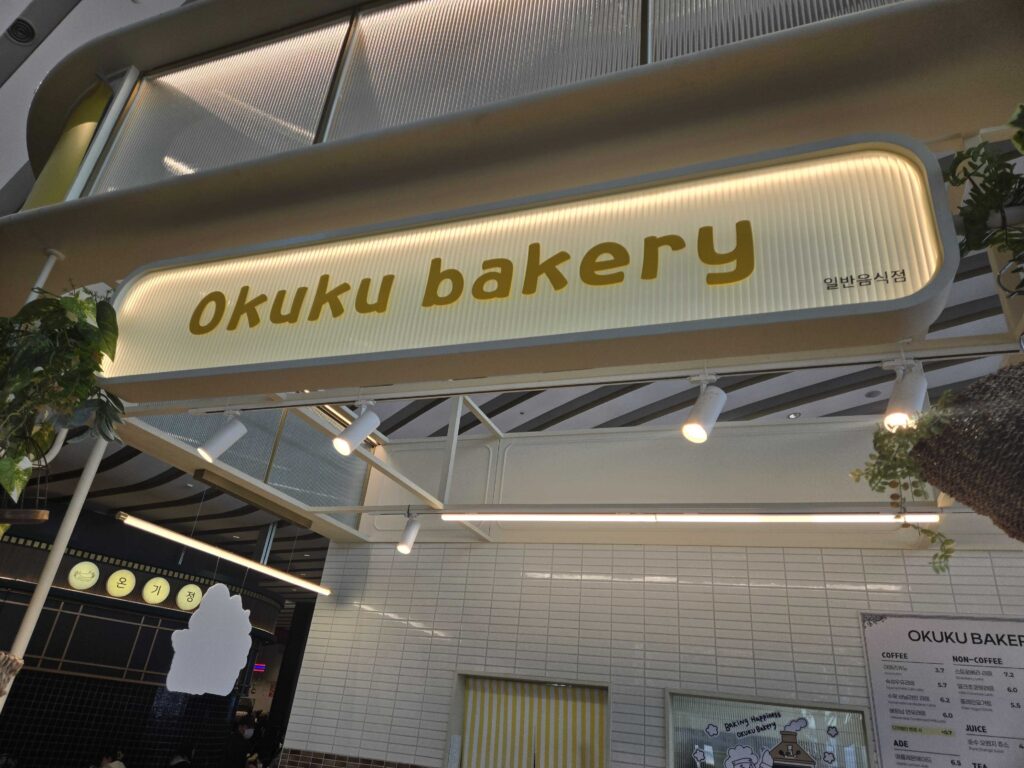 Okuku Bakery bread menu sign at Starfield Hanam with bread names and prices listed