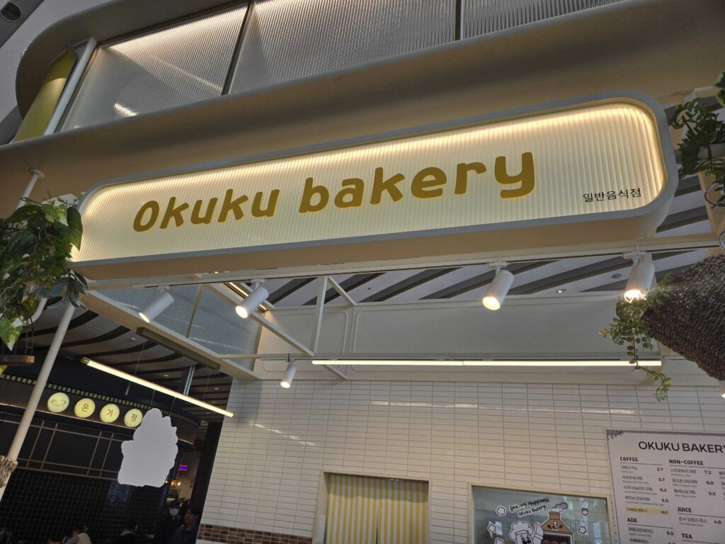 Okuku Bakery illuminated sign at Starfield Hanam seen from outside