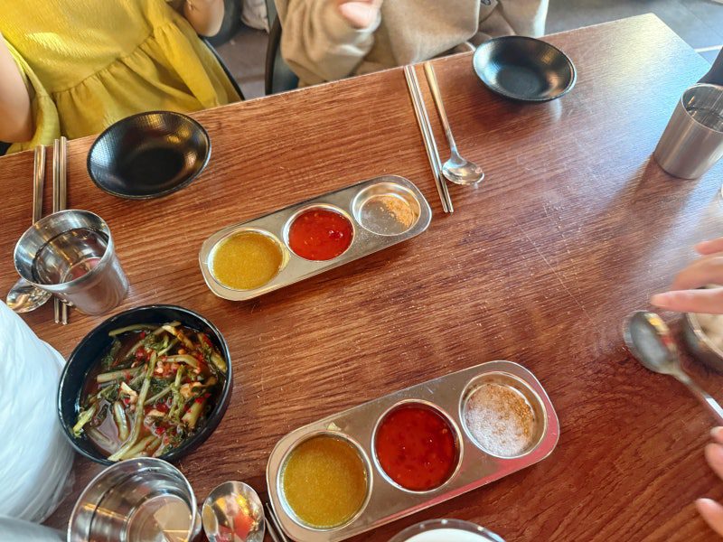 The dipping sauces and side dishes on the table