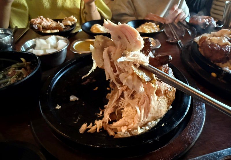 Pulling the chicken apart with tongs