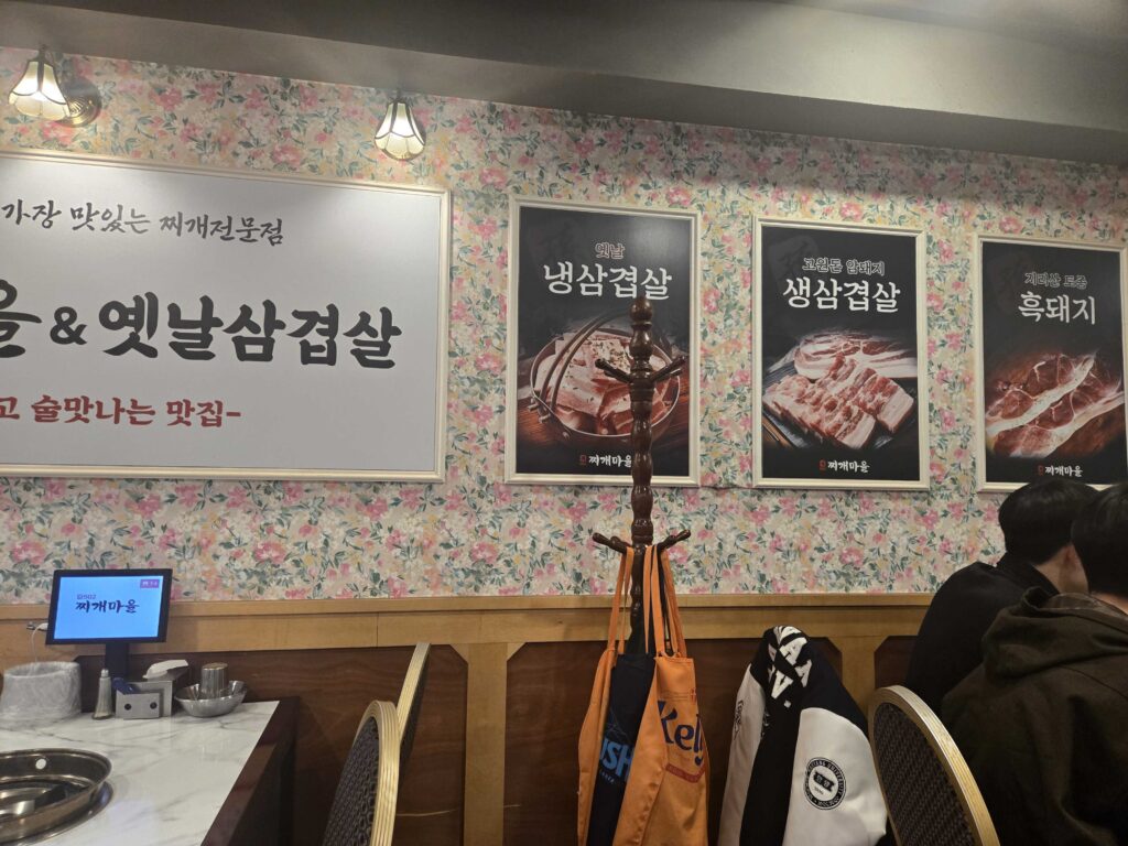 502 Jjigae Maeul wall menu showing different samgyeopsal and pork belly options including naengsamgyeopsal saengsamgyeopsal and heukdwaeji