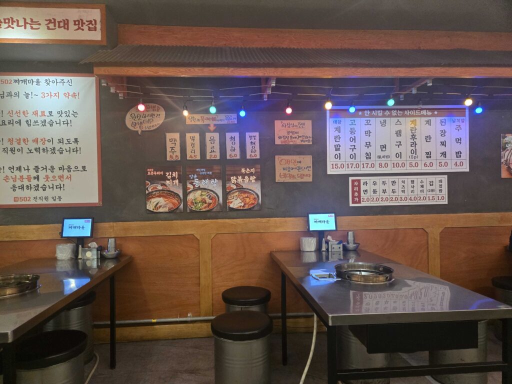 502 Jjigae Maeul interior seating area with colorful lights stew menu photos and detailed side menu price board