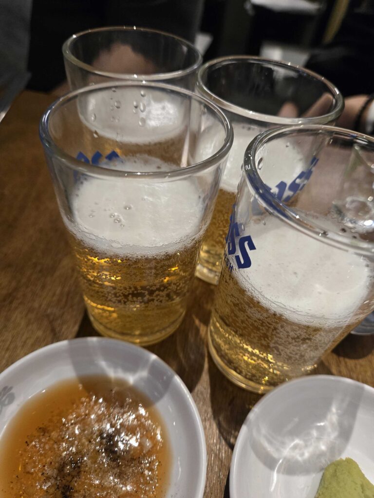 Three glasses of cold draft beer at a Korean BBQ restaurant — the perfect pairing for stone-grilled samgyeopsal