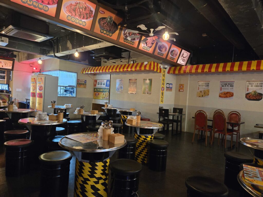 Guwoldong Kkachine Kondae interior with drum barrel tables and pojangmacha decoration