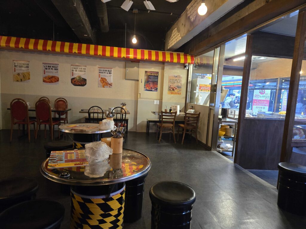 Interior seating area with retro Korean street food posters