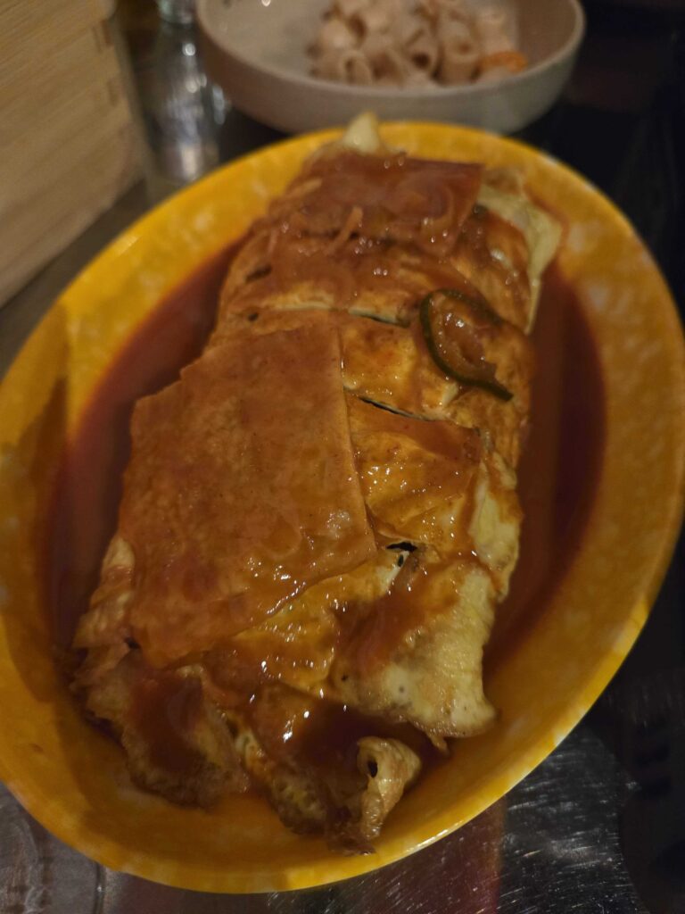 Close up of egg roll kimbap showing golden egg wrap at Guwoldong Kkachine