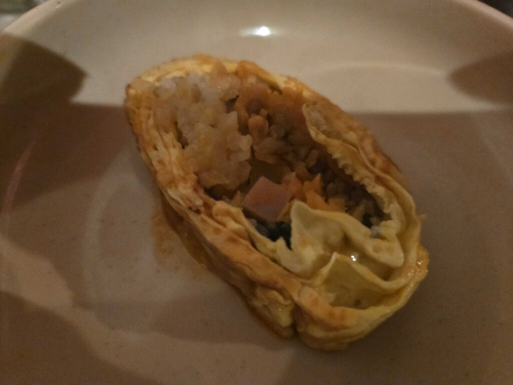 Food spread at Guwoldong Kkachine with egg roll kimbap and side dishes