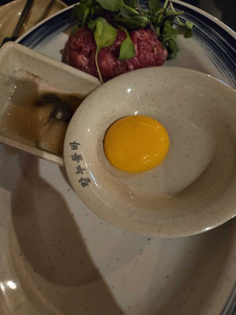 Yukhoe served with egg yolk and dipping sauce at Korean pojangmacha
