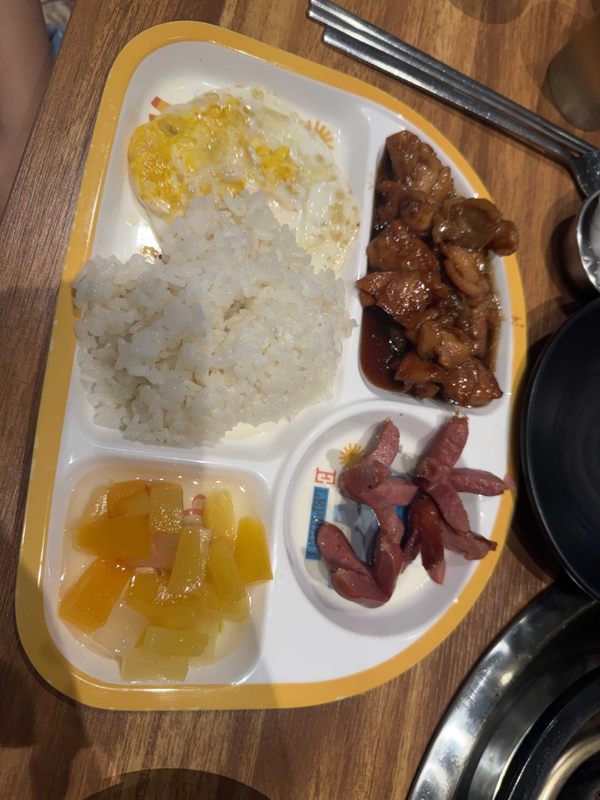 Biwabyul Dakgalbi Wirye kids menu tray with soy-glazed chicken, rice, fried egg, sausage, fruit