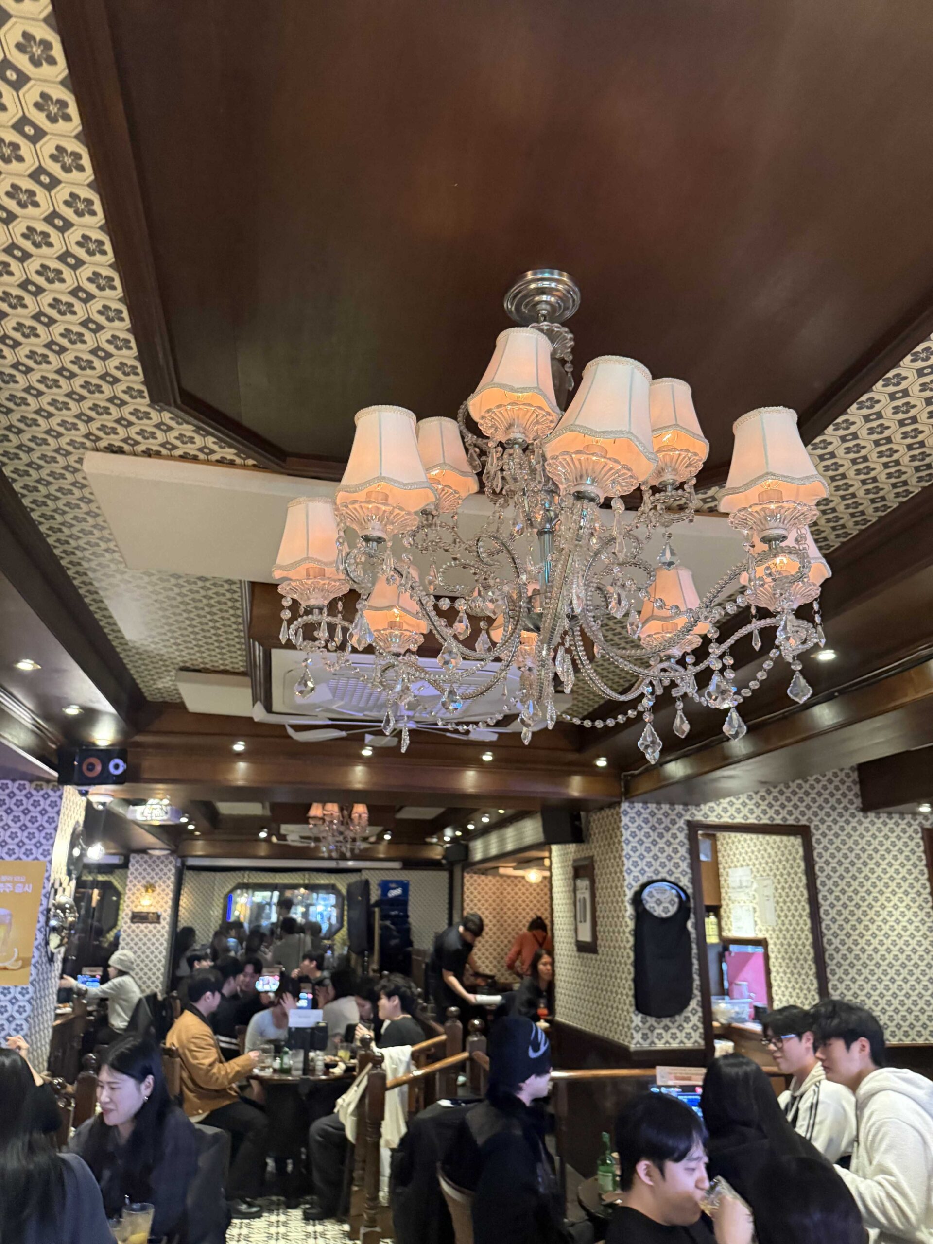 Crystal chandelier and mosaic tile floor inside packed Geumbyeol Maekju Bangi branch